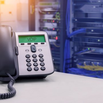 axvoice voip services overview review benefits voip phone on desk servers in the background